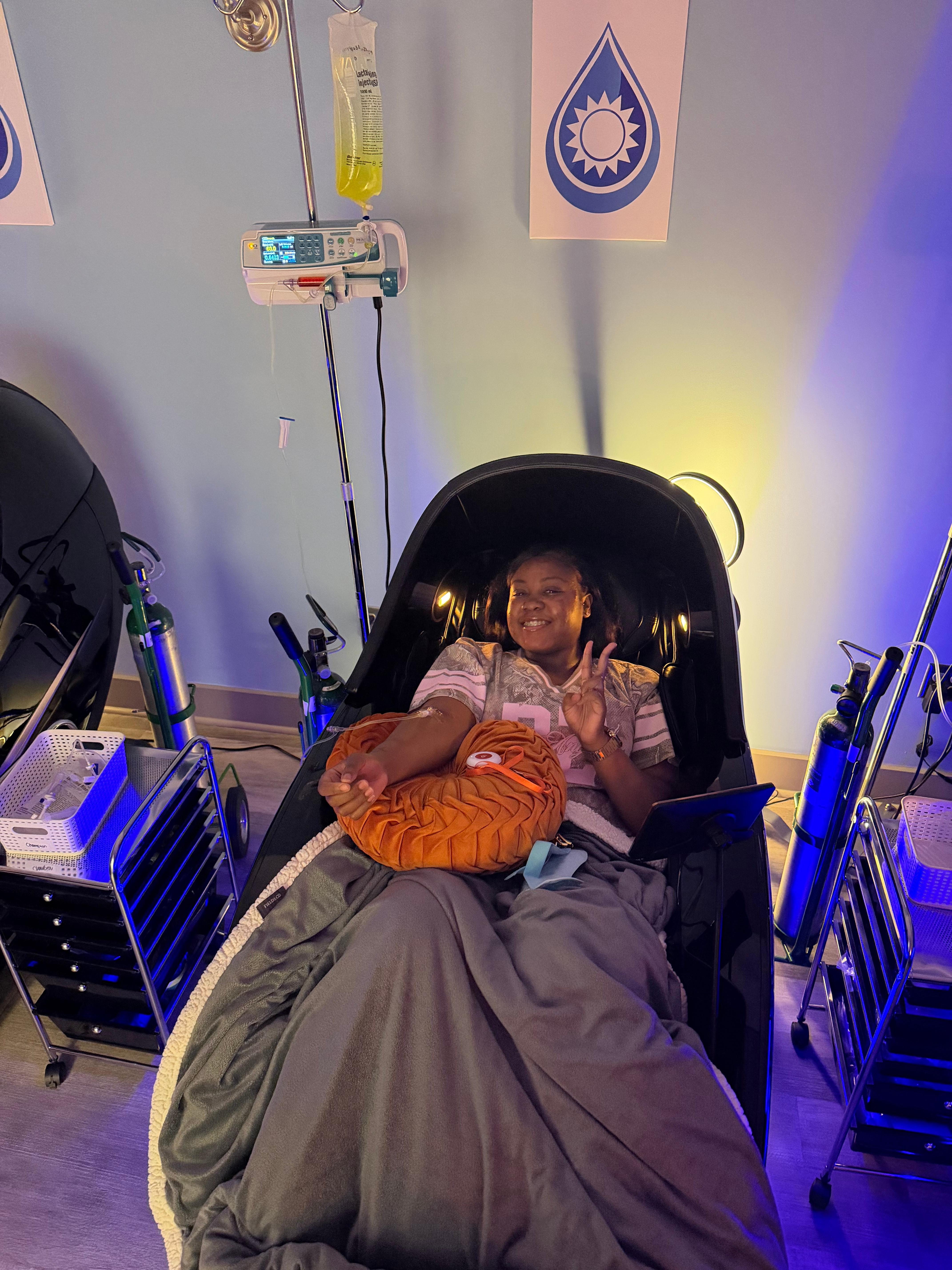 A smiling Prime IV Montgomery client giving a peace sign while receiving a relaxing vitamin IV drip