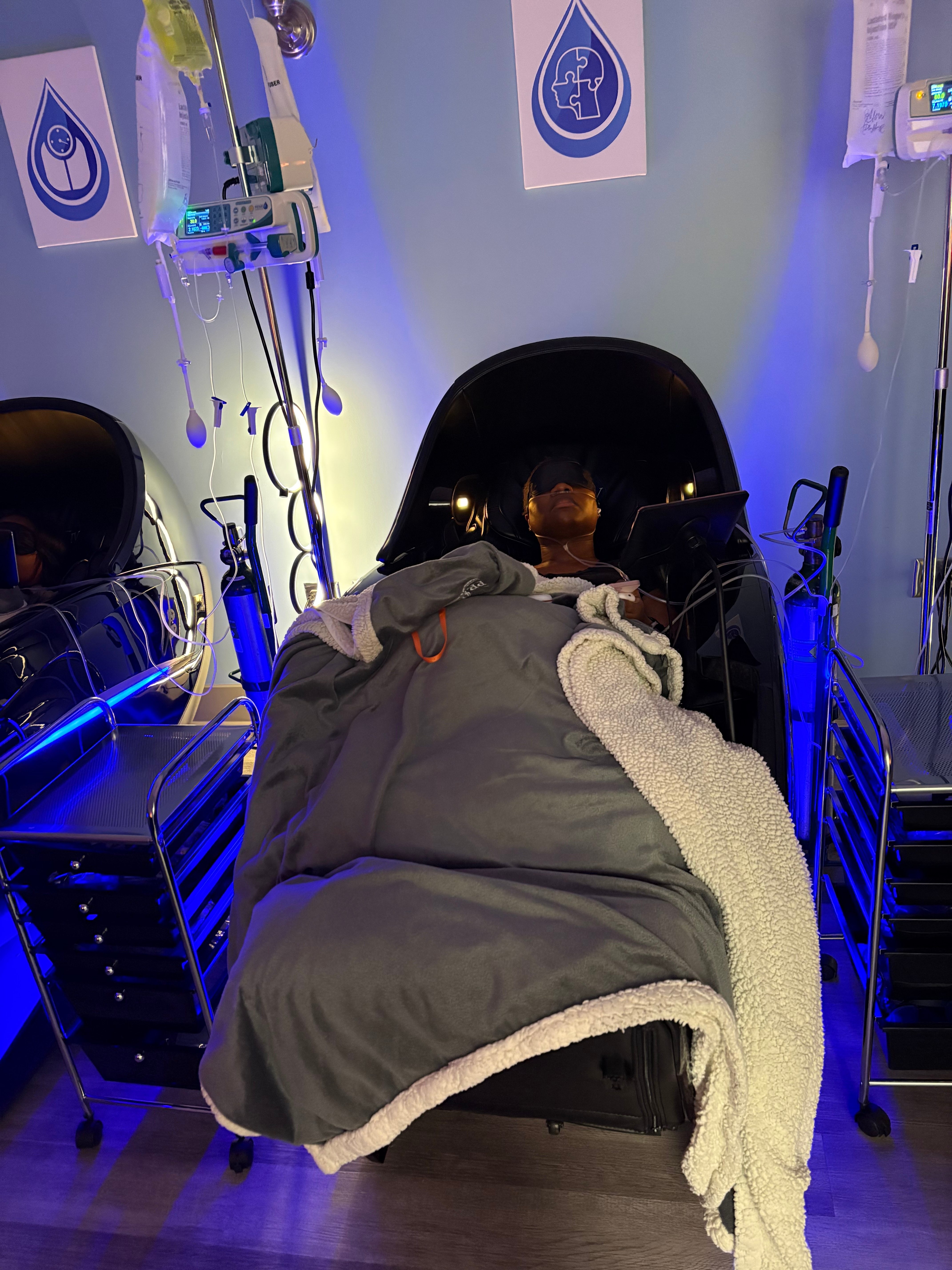 A client relaxing under a blanket in a zero-gravity massage chair during IV therapy at Prime IV Montgomery